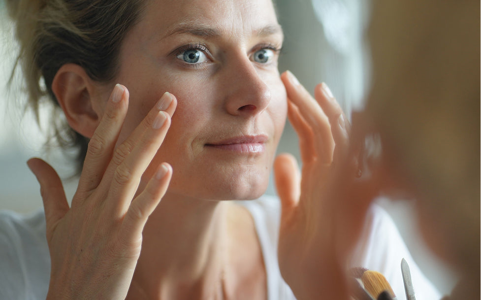 Woman examining her face in a mirror