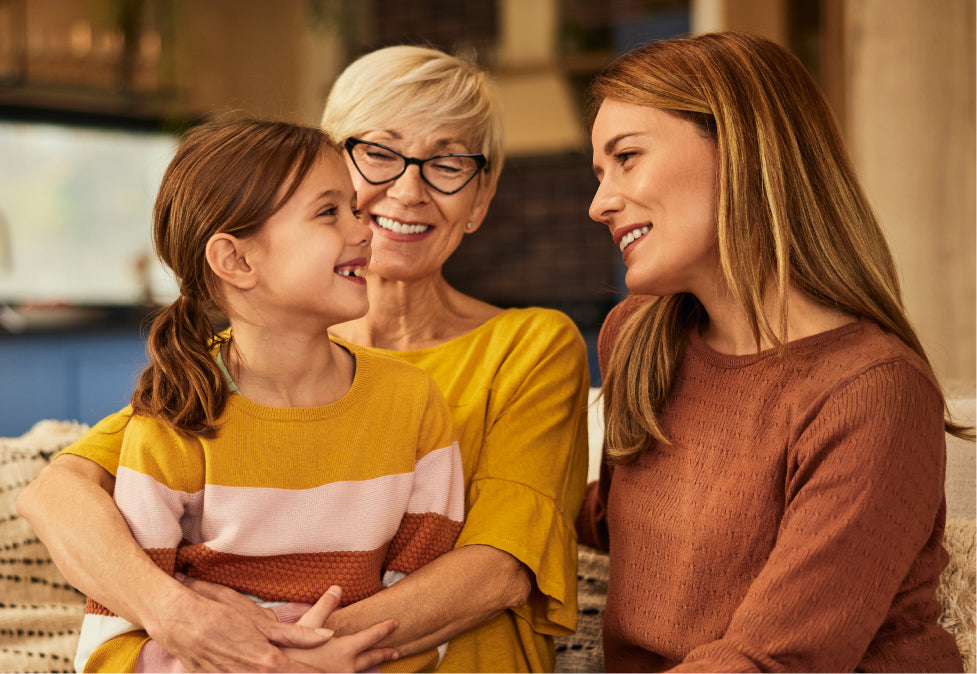 Two women and a young girl, smiling and enjoying each other's company.