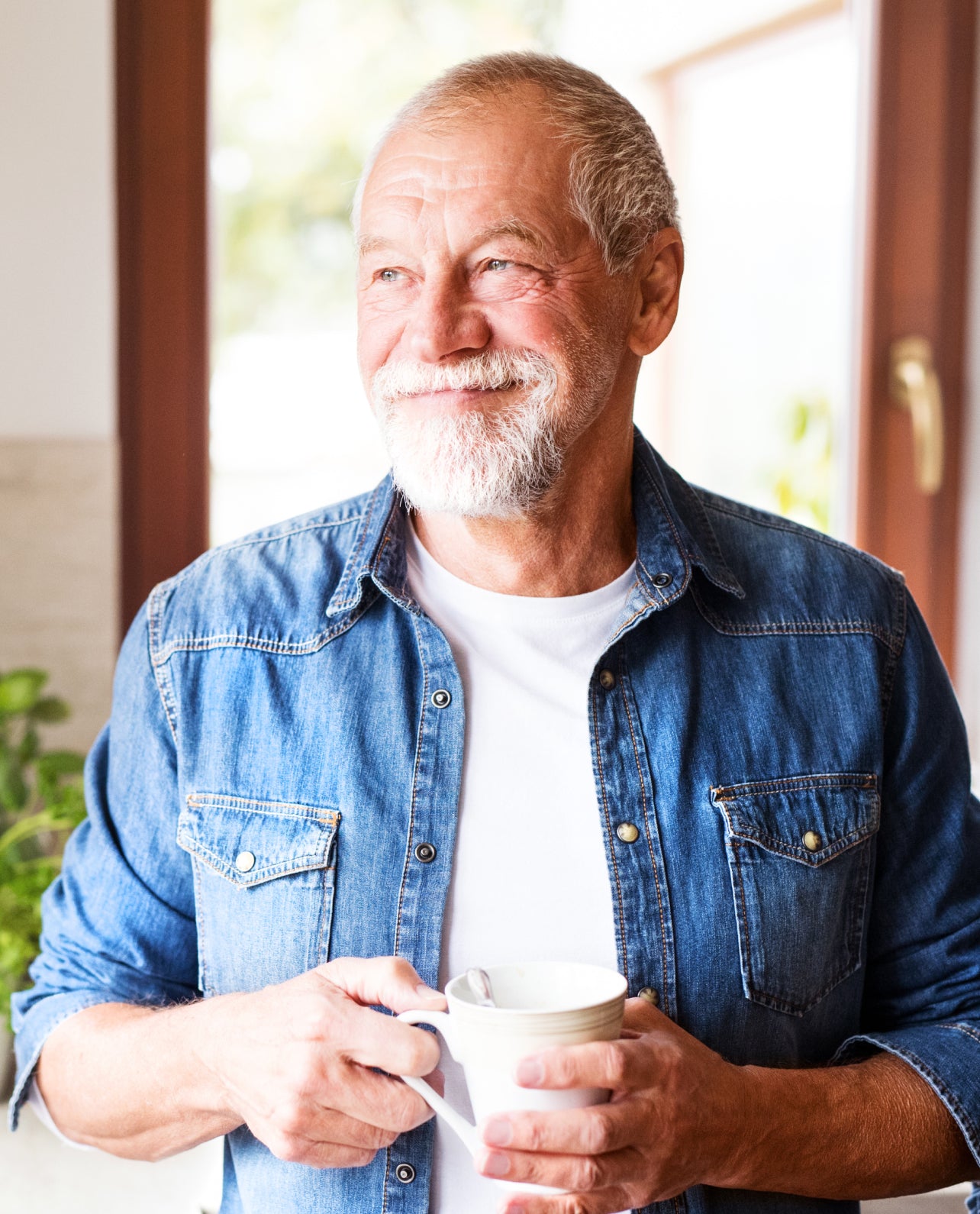 Man holding a mug indoors with a blurred background