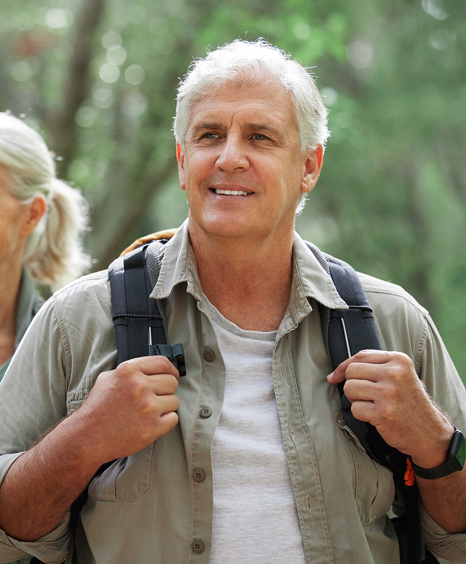 Man with a backpack walking outdoors with a blurred background