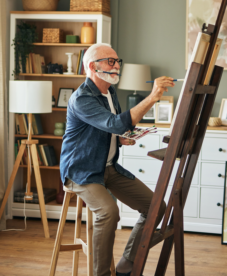 Man painting on an easel in a home setting