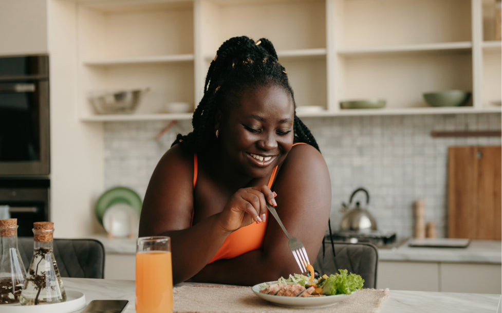Woman eating a salad in a kitchen