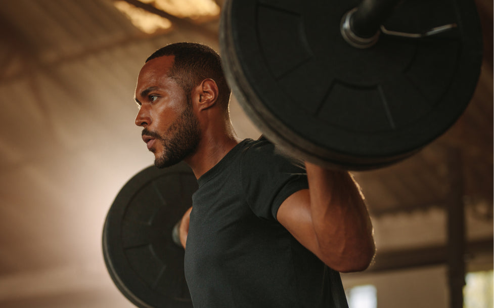 Man lifting a barbell in a gym setting